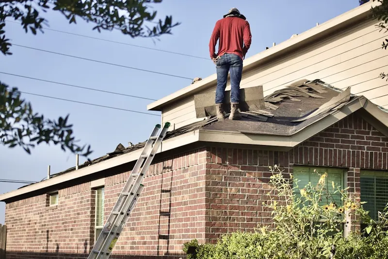 Professional roofer working on a residential roof in Ewan